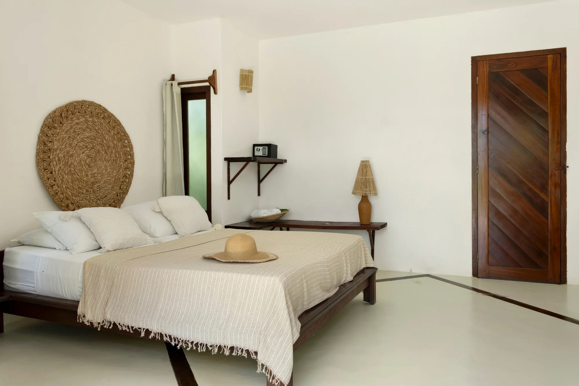 suíte jardim com cama de casal com porta na lateral na pousada País Tropical.